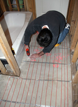 Installing heat cable for heated bathroom floor.